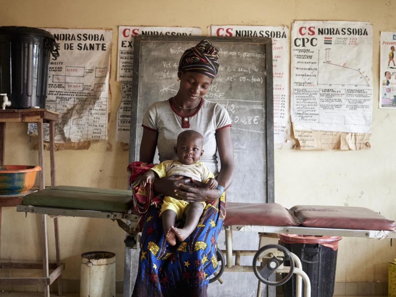 Centre de santé de Norassoba. Judicael Traore et sa fille Adama Traore 6 mois. Au centre de santé pour un mal de ventre du bébé