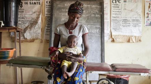Centre de santé de Norassoba. Judicael Traore et sa fille Adama Traore 6 mois. Au centre de santé pour un mal de ventre du bébé